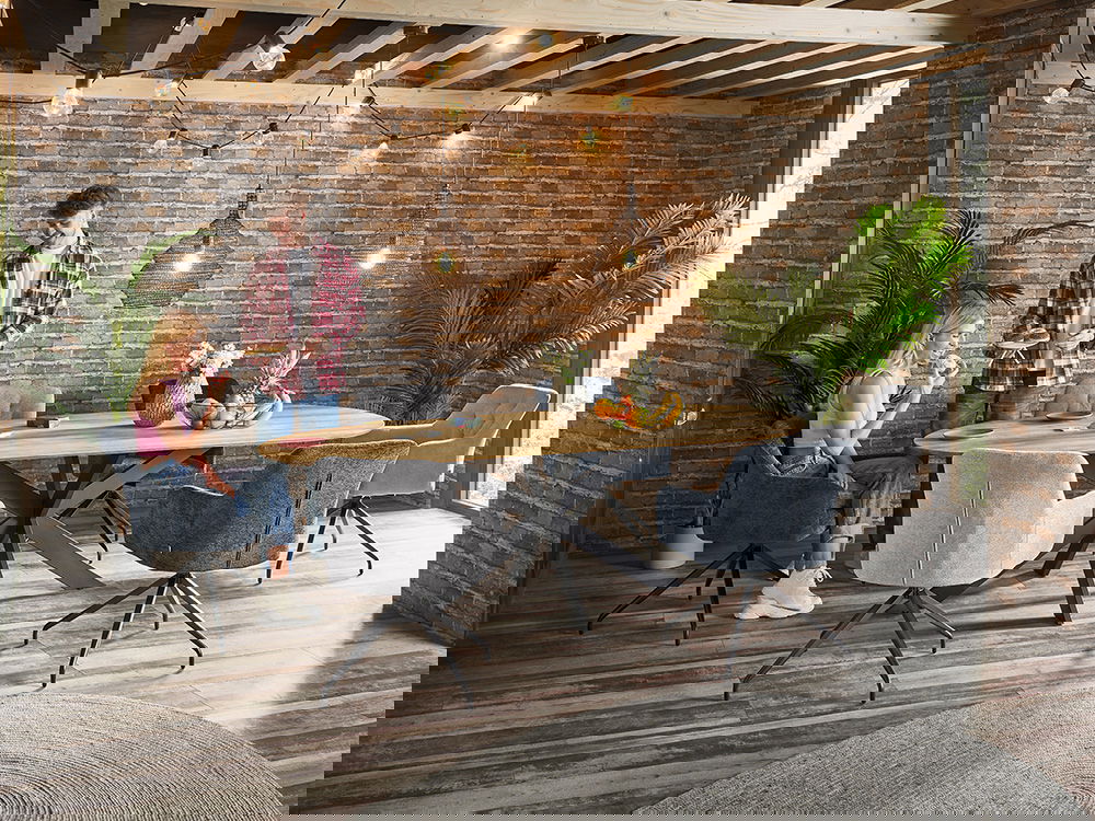 Ein Holztisch steht auf einem schwarzen Metallgestell, umgeben von drehbaren Stühlen.