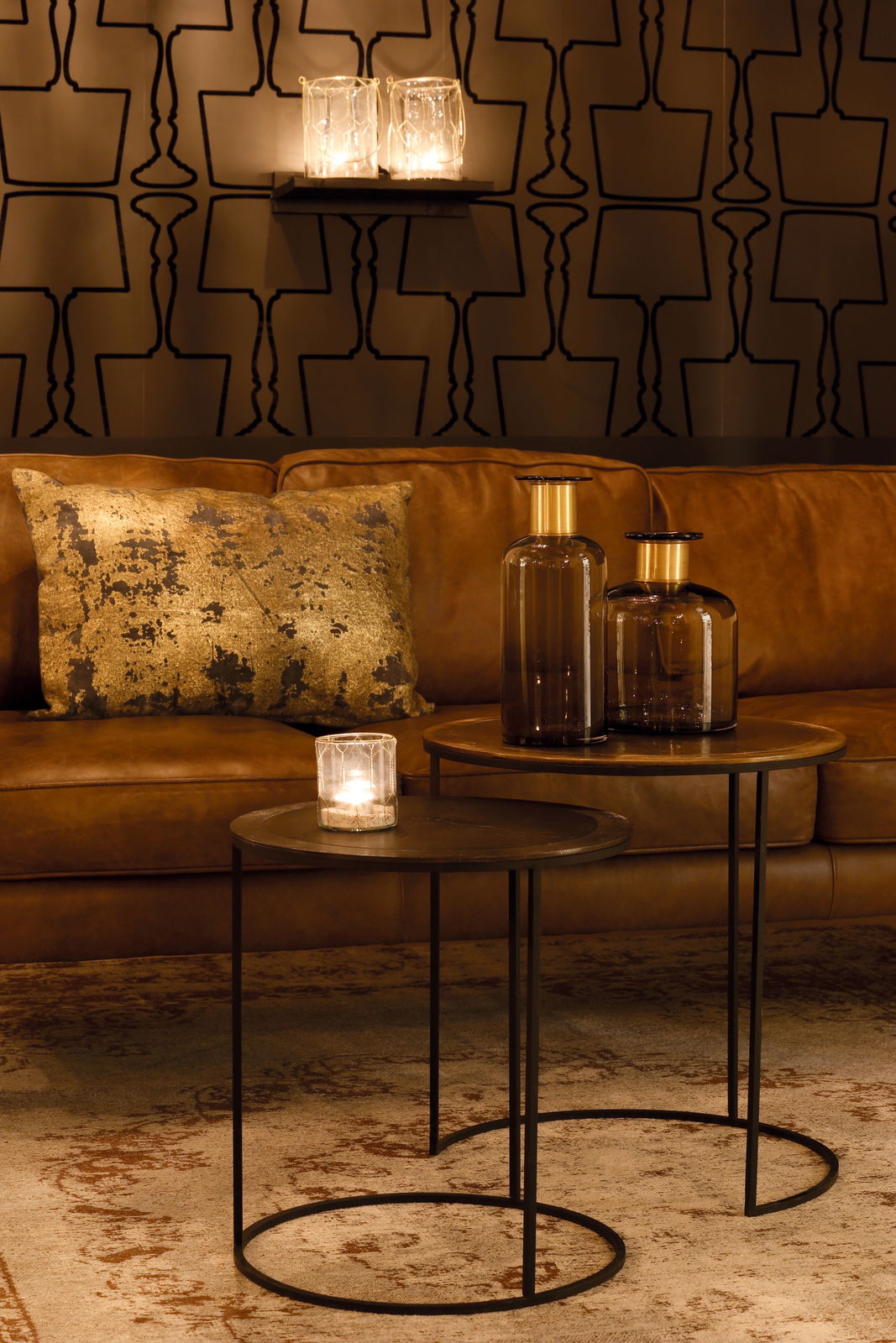 Light&Living Beistelltisch-Set TALCA Zwei runde Beistelltische in einem gemütlichen Wohnzimmer, mit braunem Ledersofa und dekorativen Glasvasen, aus seitlicher Perspektive betrachtet.