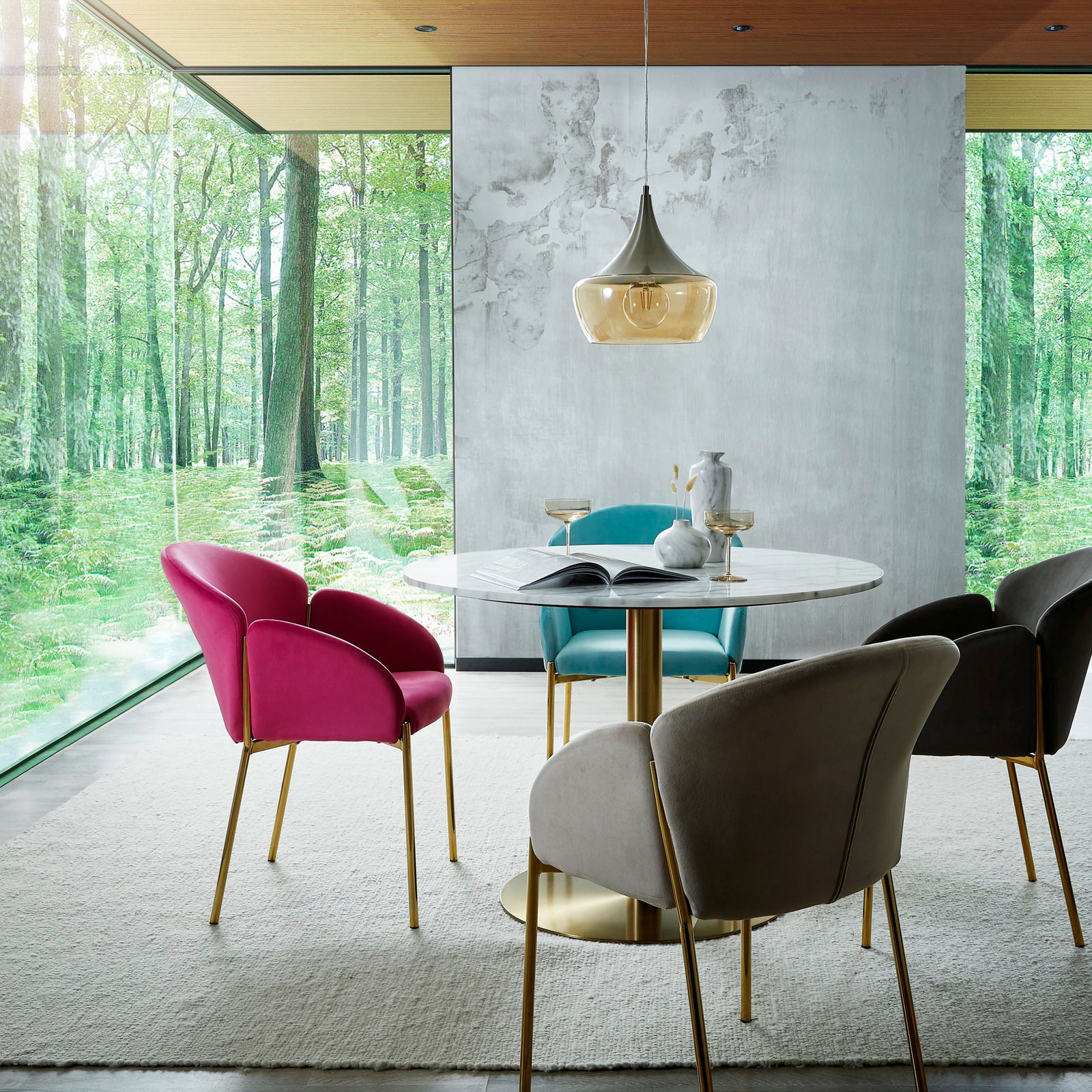 Esszimmer mit modernem Design, bestehend aus einem runden Tisch und bunten Sesseln der Serie SUNNY von Livetastic. Die Perspektive zeigt den Raum mit großen Fenstern, die einen Blick auf einen grünen Wald bieten.
