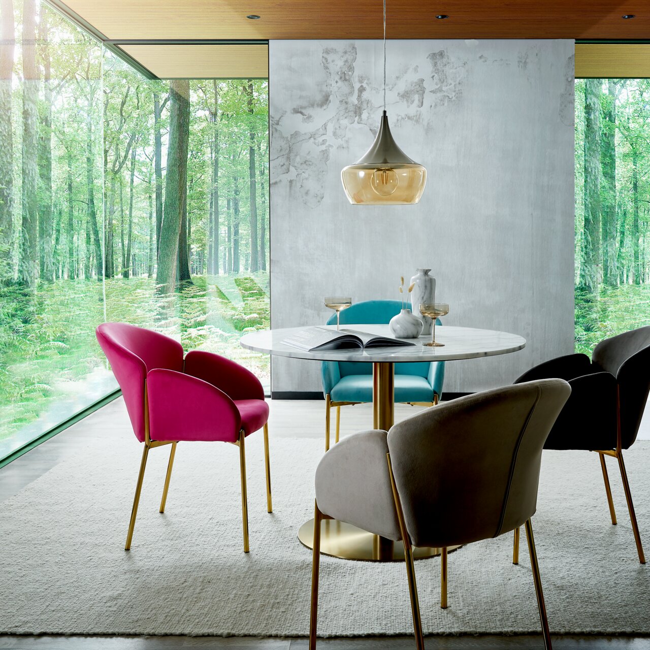 Esszimmer mit modernem Design, bestehend aus einem runden Tisch und bunten Sesseln der Serie SUNNY von Livetastic. Die Perspektive zeigt den Raum mit großen Fenstern, die einen Blick auf einen grünen Wald bieten.