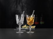 Zwei elegante Cocktailgläser mit Strohhalmen, eines leer und eines mit Getränk und Limettenscheibe, auf schwarzem Hintergrund, seitliche Perspektive.