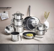 Topfset Elegance 10-tlg. aus Edelstahl, bestehend aus mehreren Töpfen und Pfannen mit Glasdeckeln, auf einer Küchenarbeitsplatte von vorne fotografiert.