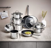 Topfset Elegance 10-tlg. aus Edelstahl, bestehend aus mehreren Töpfen und Pfannen mit Glasdeckeln, auf einer Küchenarbeitsplatte von vorne fotografiert.