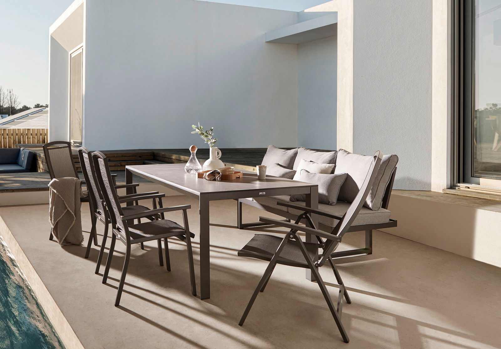 Moderne Terrasse mit Esstisch und Stühlen, seitliche Perspektive