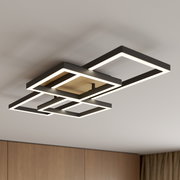 Moderne LED-Deckenleuchte mit vier überlappenden quadratischen Rahmen in Schwarz mit Holzoptik-Mittelteil, warmweiß leuchtend, Ansicht schräg von unten an der Decke montiert