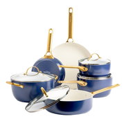 Zesdelige pannenset in blauw met gouden handgrepen, bestaande uit potten en pannen met glazen deksels, gefotografeerd vanuit een vooraanzicht.
