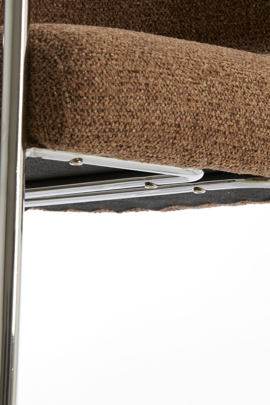 Nahaufnahme eines braunen Armlehnstuhls mit Metallrahmen, seitliche Perspektive