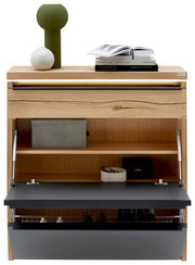 Schuhschrank aus hellem Holz mit geöffneter Klappe in Anthrazit, Innenfächern und Drahtkorb, oben mit Deko und Büchern, Frontansicht.