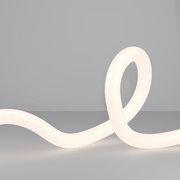 LED-Lichtschlauch in geschwungener Form auf grauem Hintergrund, seitliche Perspektive