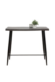 Moderner Bartisch mit dunkler Holzplatte und schwarzen Metallbeinen, frontal fotografiert. Dekoriert mit einer kleinen Pflanze und einem Glasgefäß.