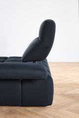 Seitenansicht einer modernen, dunkel gepolsterten Eckgarnitur mit verstellbarer Rückenlehne auf Holzfußboden.