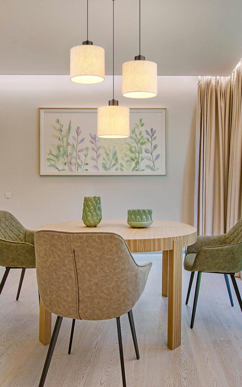 Drei moderne Hängeleuchten in einem Esszimmer, aus der Perspektive von unten betrachtet.