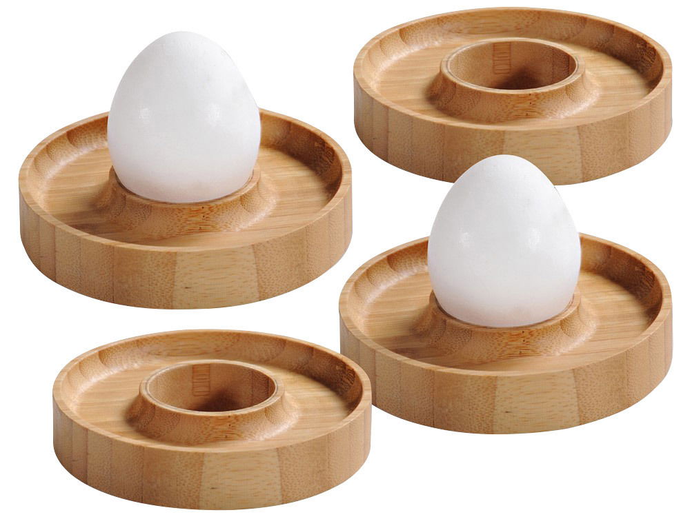 Vier runde Eierbecher aus Bambus, von oben betrachtet, mit zwei weißen Eiern in zwei der Becher.