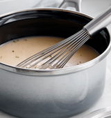Nahaufnahme eines Stieltopfs in galaxy grey mit einem Schneebesen, der in einer cremigen Suppe rührt.