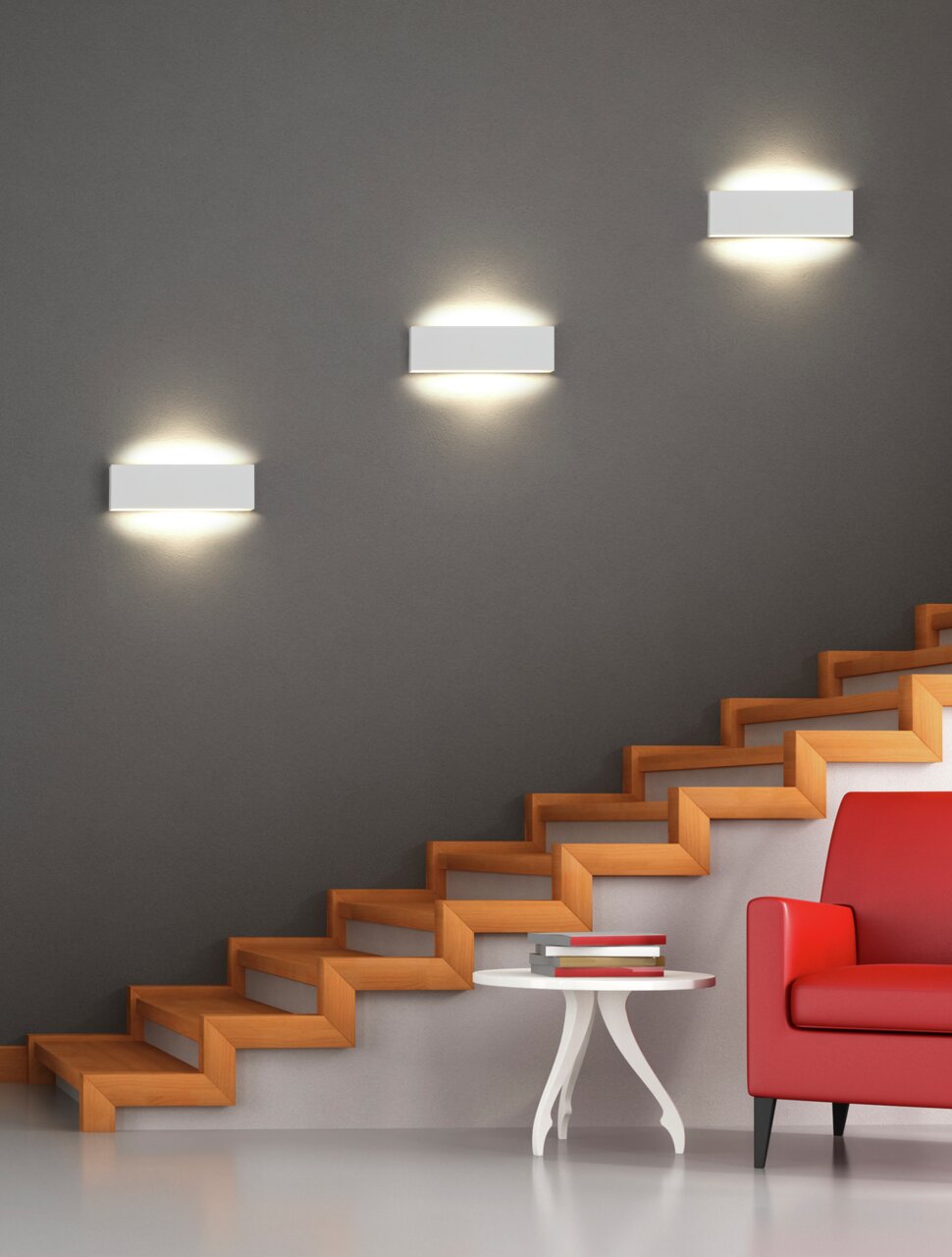 Trio Leuchten Wandlamp CONCHA Moderne wandlamp Concha in minimalistisch design, bevestigd aan een grijze muur boven een trap, met warm licht dat zowel naar boven als naar beneden schijnt.
