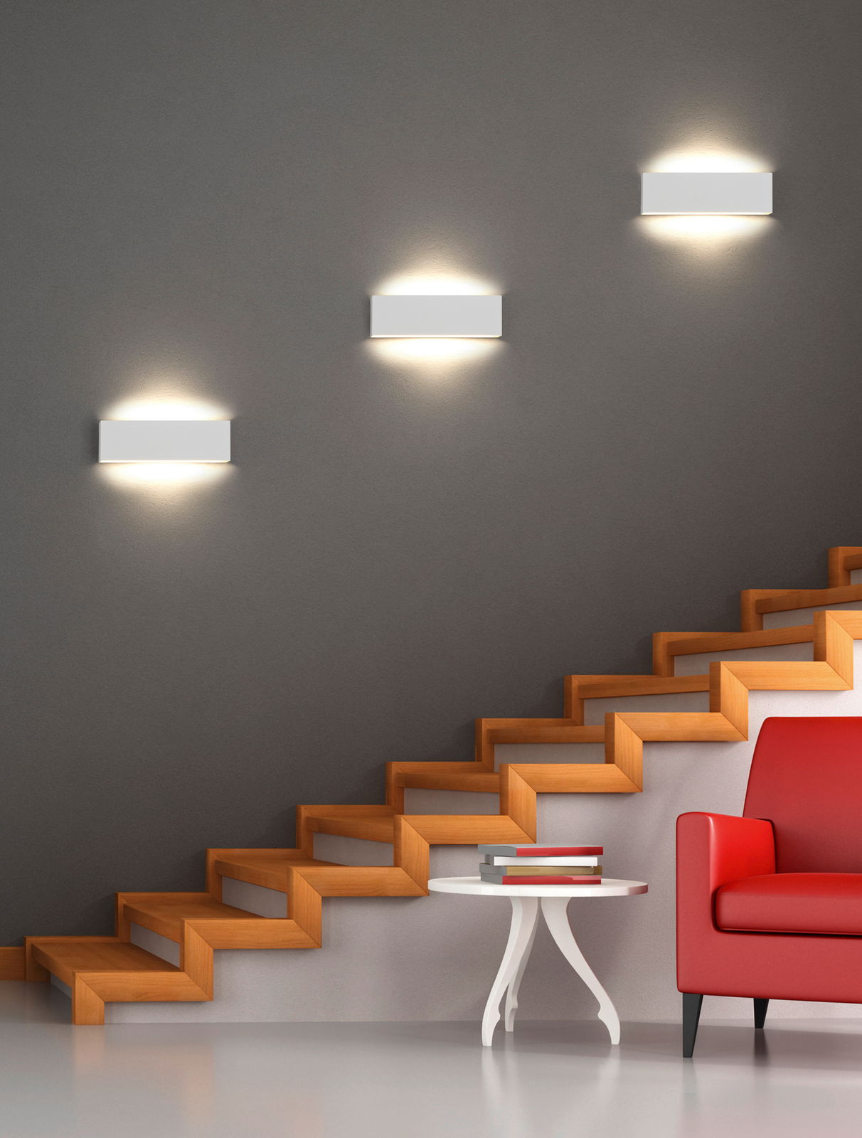 Moderne Wandleuchte Concha in minimalistischem Design, montiert an einer grauen Wand über einer Treppe, mit warmem Licht nach oben und unten strahlend.