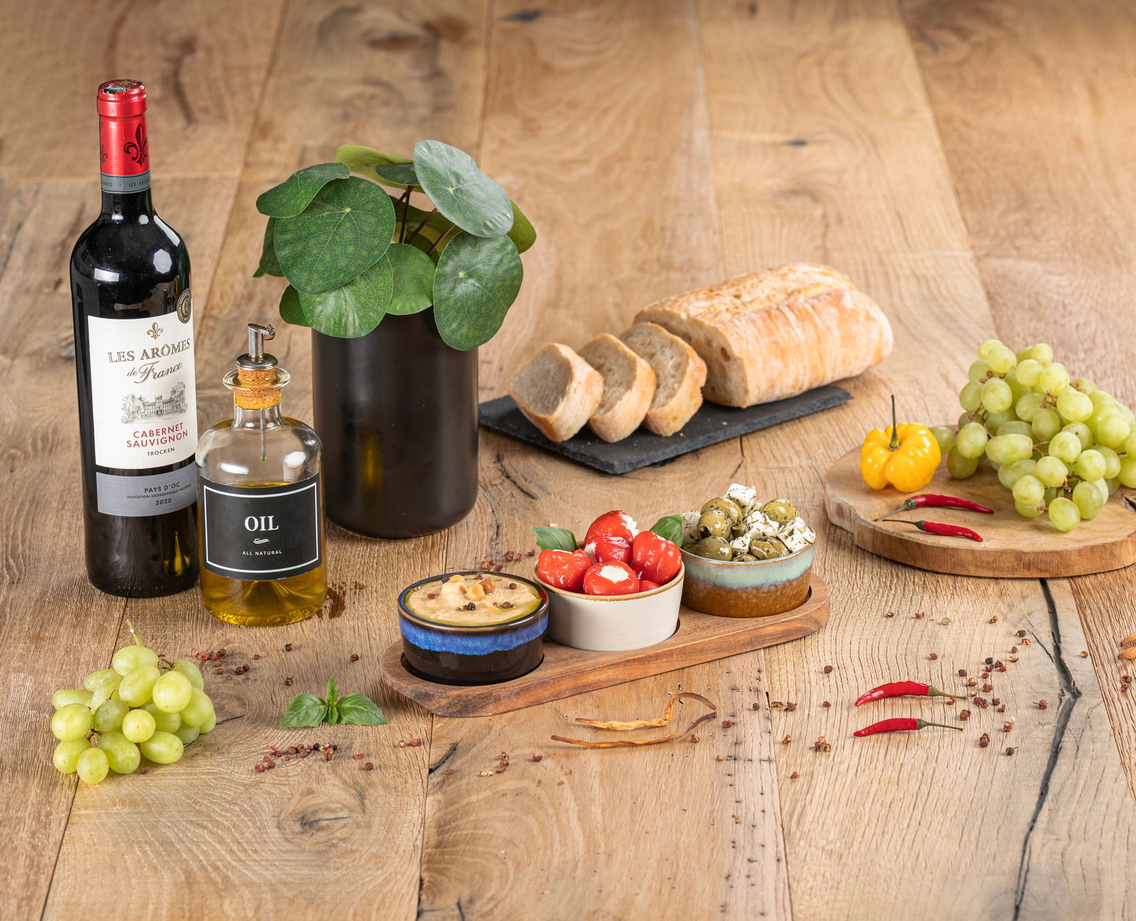 Moritz & Moritz Akazienbrett inkl. Dipschalen Akazienbrett mit drei Schalen, gefüllt mit Antipasti, auf einem Holztisch. Perspektive von oben.