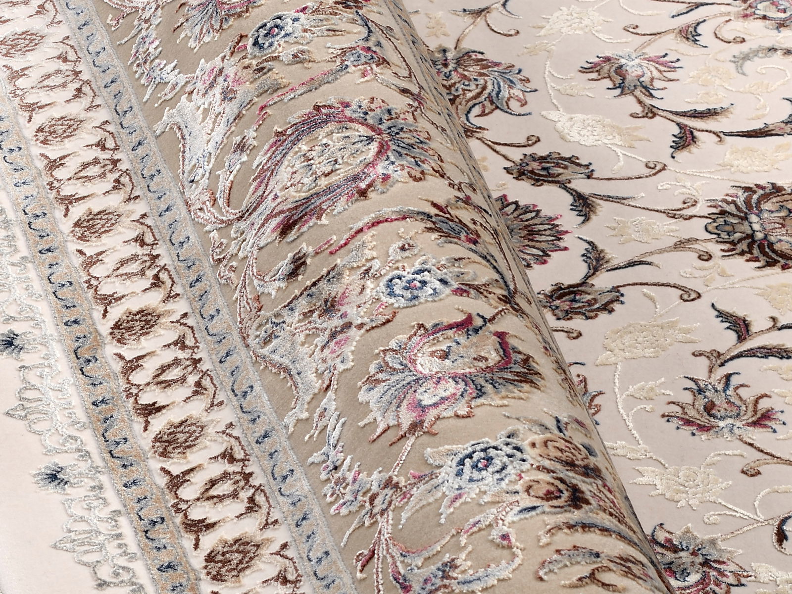 Nahaufnahme eines orientalischen Teppichs mit floralen Mustern in Beige, Rot und Blau, teilweise aufgerollt.