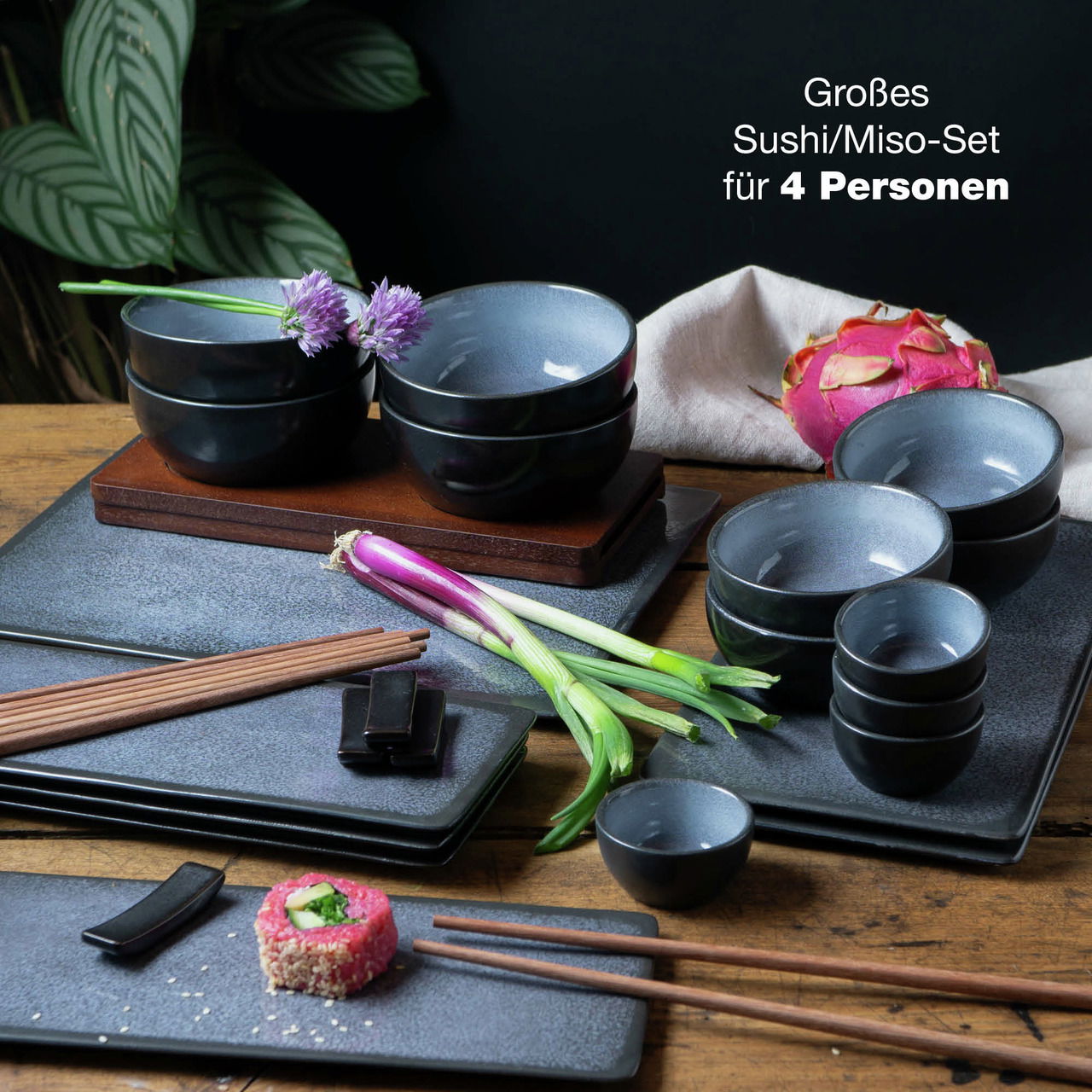 29-teiliges Sushi-Set in Blau für 4 Personen, bestehend aus Schalen und Tellern, auf einem Tisch mit frischen Zutaten, seitliche Perspektive.