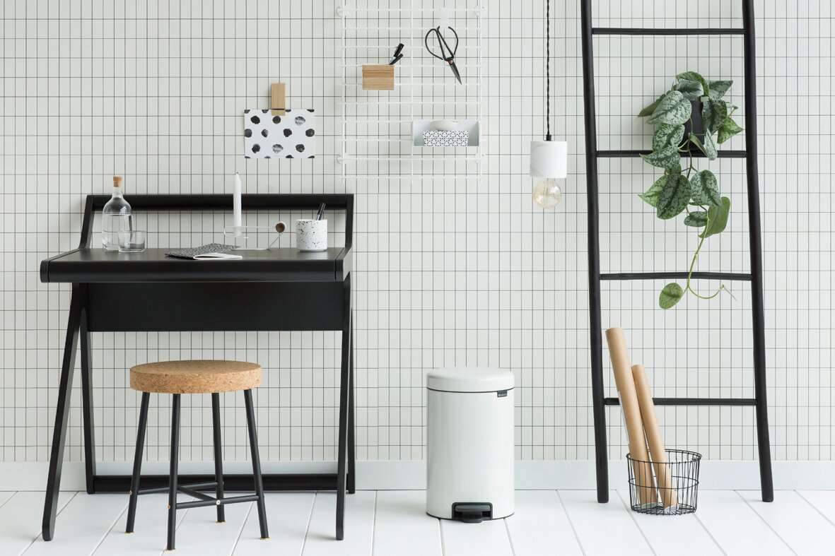 Moderner weißer Treteimer in einem stilvollen, minimalistischen Raum, seitliche Perspektive.