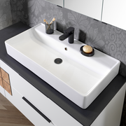 Moderner Waschtisch mit rechteckigem Becken, schwarzem Wasserhahn und Seifenschale, von oben fotografiert.