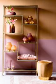 Offenes Regal mit goldfarbenem Rahmen, dekoriert mit rosa und goldenen Vasen und Kerzenhaltern, seitliche Perspektive.