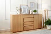 Holz-Sideboard mit Schubladen und Türen, dekoriert mit Pflanzen und Bildern, seitliche Perspektive