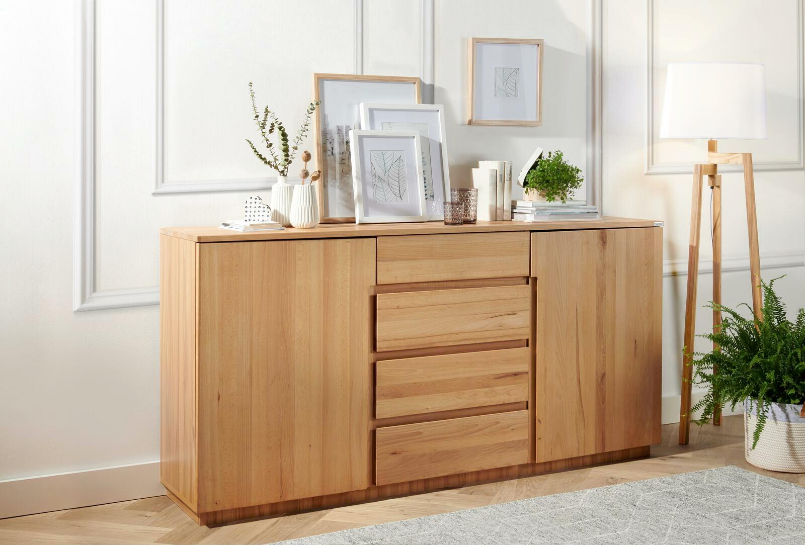 Holz-Sideboard mit Schubladen und Türen, dekoriert mit Pflanzen und Bildern, seitliche Perspektive