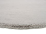 Nahaufnahme eines weichen, grauen Fellteppichs mit flauschiger Textur.