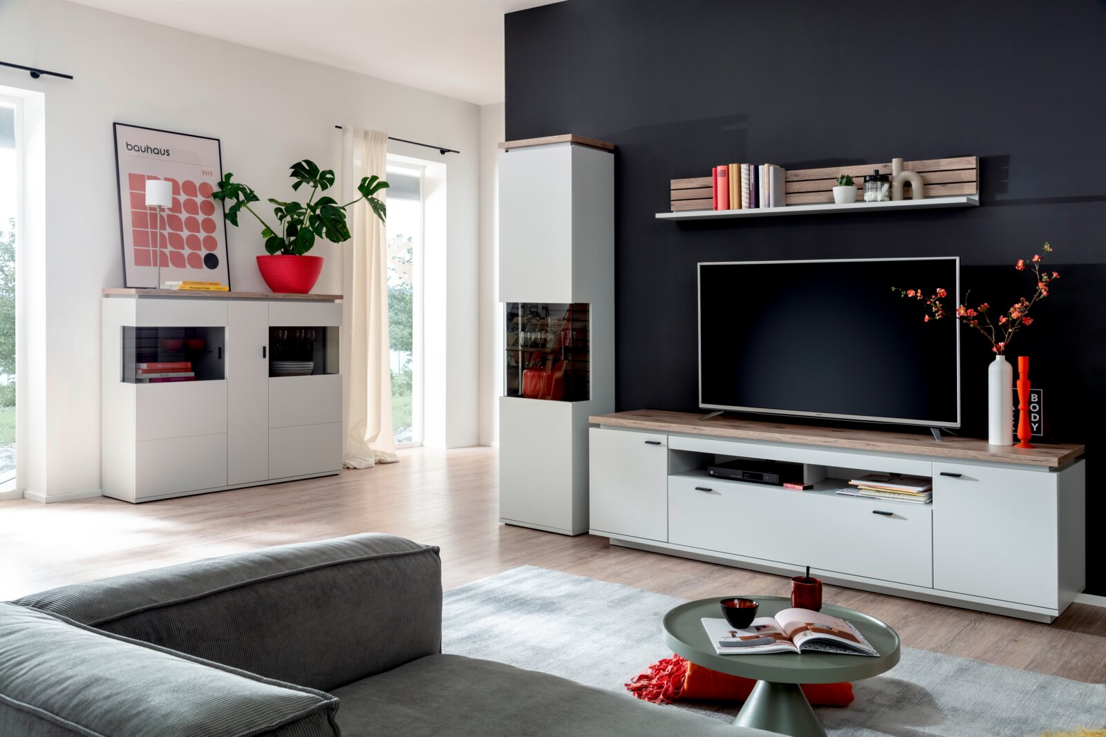 Stylife Highboard ESTEPONA Modernes Wohnzimmer-Set mit weißer TV-Bank, Vitrine und Sideboard mit Holzoptik-Abdeckplatten vor dunkler Akzentwand, frontal in leichter Weitwinkelperspektive aufgenommen