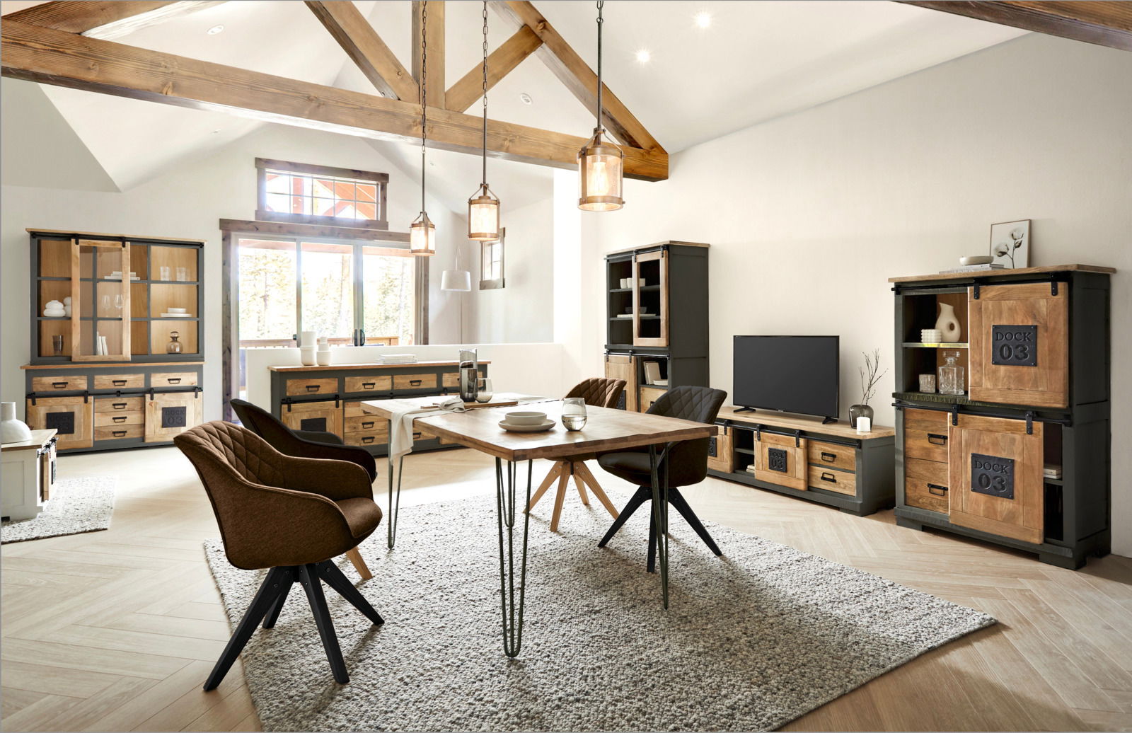 Wohnzimmer mit modernen Holzmöbeln, darunter ein Sideboard, ein Highboard und ein Lowboard, in einem hellen Raum mit Holzbalkendecke, aus der Perspektive von vorne betrachtet.
