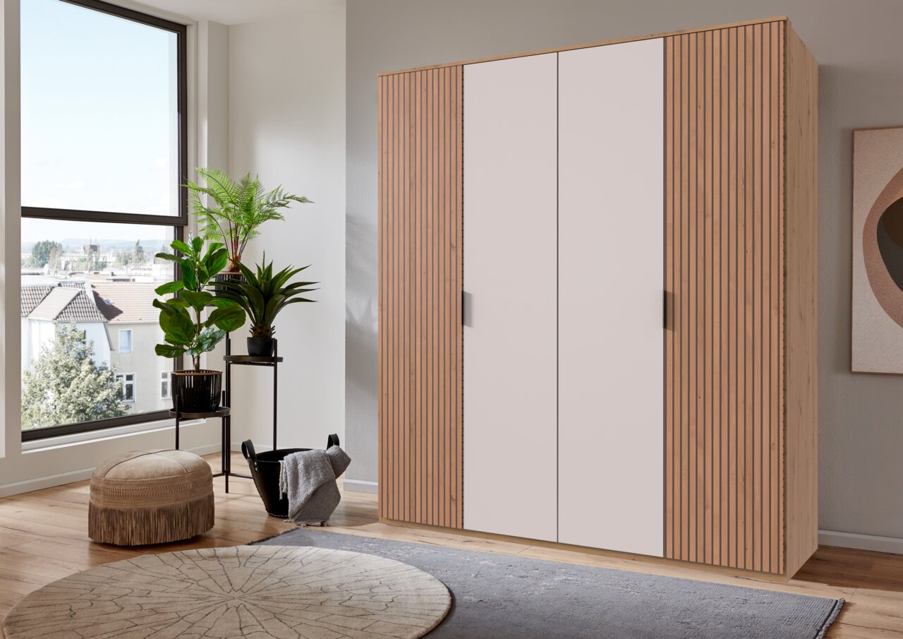 Moderner Drehtürenschrank mit vier Türen in Holzoptik, seitliche Perspektive.
