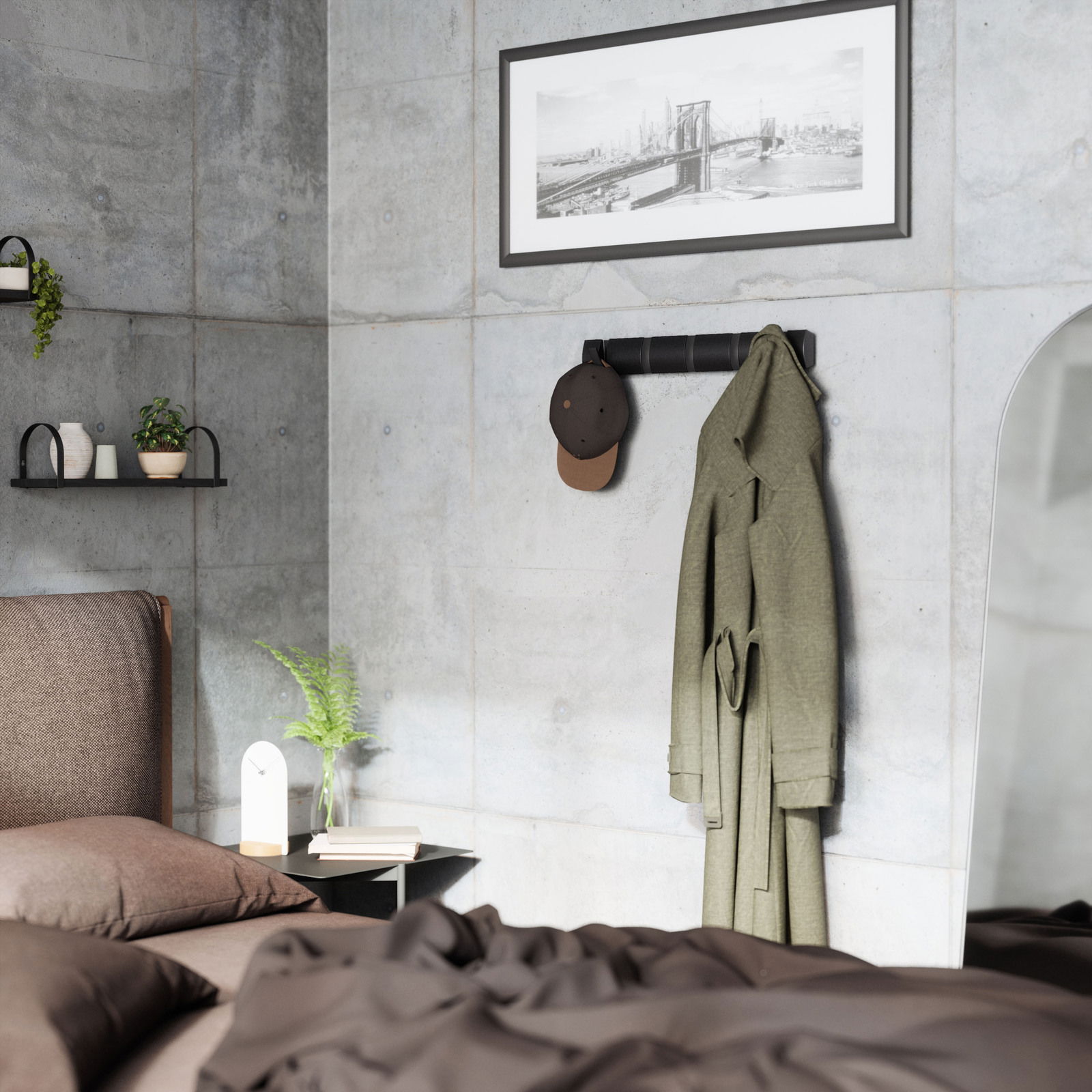 Moderne Wandgarderobe Umbra FLIP in einem stilvollen Schlafzimmer, frontal an der Betonwand montiert, mit einem Mantel und einer Mütze behängt.