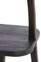 Nahaufnahme eines dunklen Holzstuhls, Fokus auf Sitzfläche und Rückenlehne, seitliche Perspektive