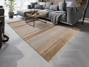 Moderner Designer-Teppich in warmen Erdtönen mit geometrischem Muster, ausgelegt in einem stilvollen Wohnzimmer mit grauem Sofa und Couchtisch, seitliche Perspektive.