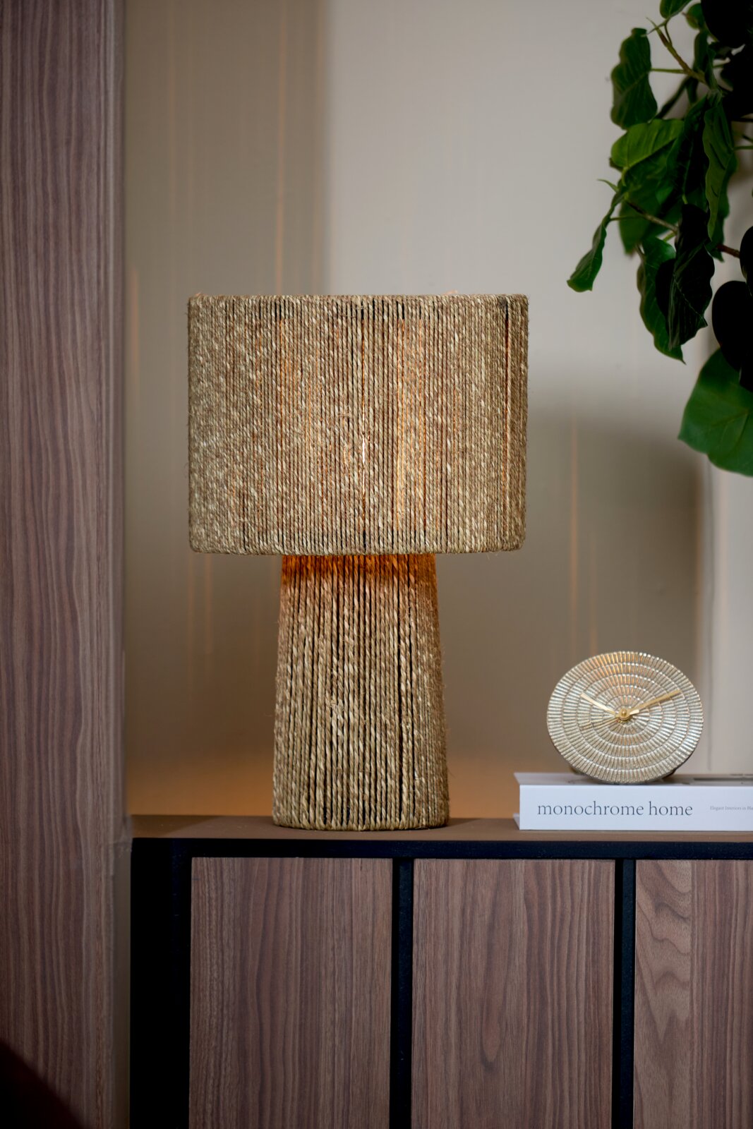Light&Living klok BOJANO Goldene Tischuhr BOJANO mit einem Durchmesser von 15,5 cm, frontal auf einem Regal neben einer dekorativen Lampe und einem Buch platziert.