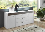 Modernes weißes Sideboard mit Holzdetails, dekoriert mit Pflanzen und Skulptur, in einem hellen Raum mit Blick auf den Garten, seitliche Perspektive.