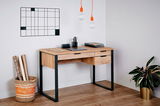 Moderner Schreibtisch aus Holz mit Metallrahmen, zwei Schubladen und stilvoller Dekoration, seitliche Perspektive.