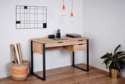 Moderner Schreibtisch aus Holz mit Metallrahmen, zwei Schubladen und stilvoller Dekoration, seitliche Perspektive.
