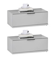 Zwei moderne, graue Nachtkonsolen mit einer Tasse und Büchern darauf, seitliche Perspektive.