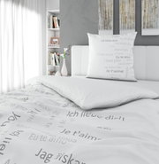 Bettwäsche-Set mit internationalem Liebesbotschafts-Design in einem modernen Schlafzimmer, seitliche Perspektive