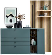 Moderne Sideboardkombination VANYA von Venjakob in stilvollem Design, mit grünen Schubladen und Glastür, dekoriert mit Vasen und Kunstwerk, aus frontaler Perspektive.