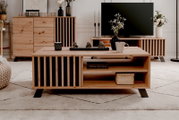 Moderne houten salontafel met zwarte accenten, gefotografeerd van voren, versierd met een vaas, een kopje en beeldjes.