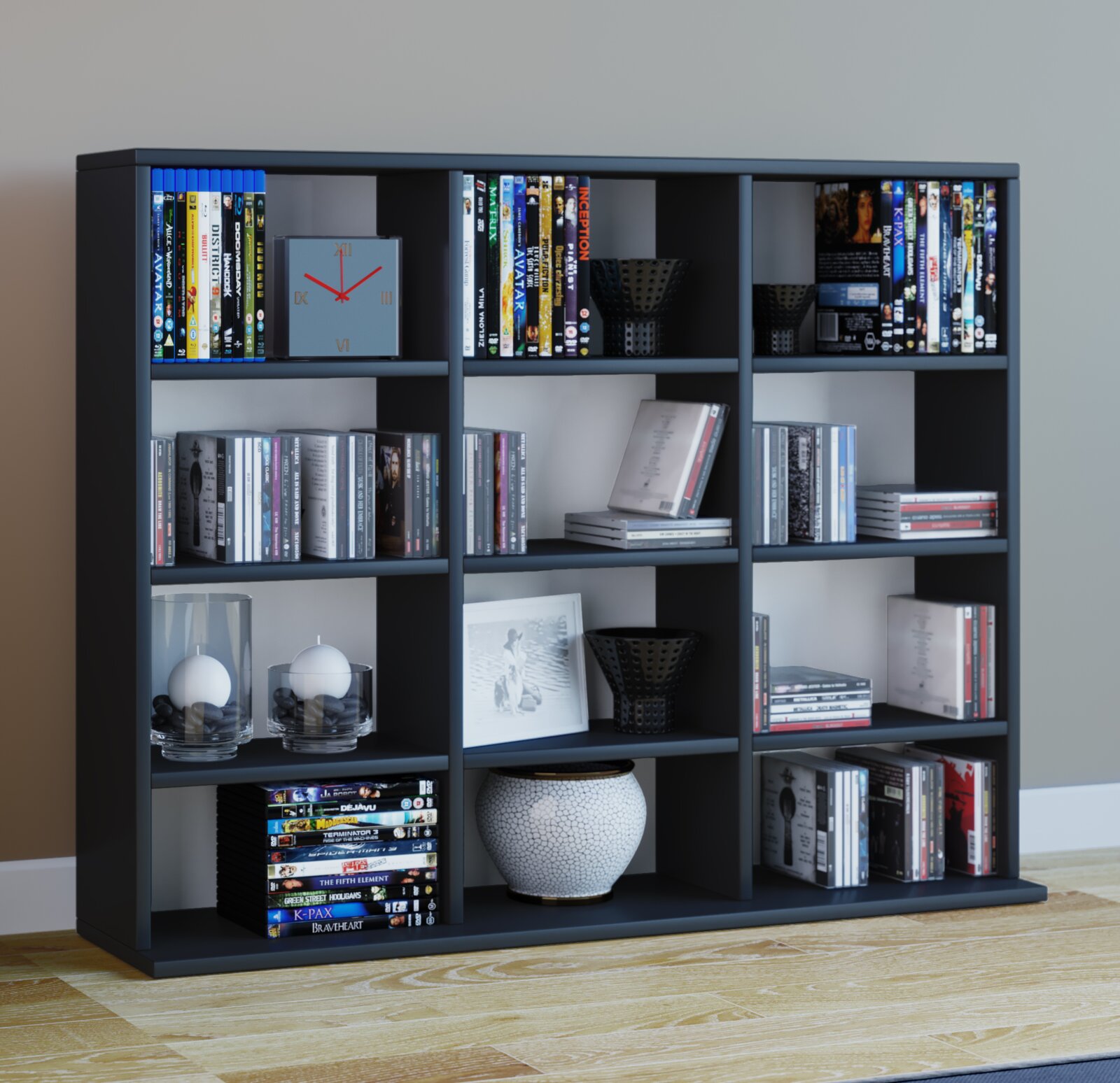 Modernes, dunkelgraues Regal mit mehreren offenen Fächern, gefüllt mit DVDs/Büchern und Deko (Uhr, Kerzen, Vase), frontale Perspektive.