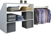 Weißes offenes Kleiderschrank-Regal mit zwei Ablagefächern und seitlicher Kleiderstange, bestückt mit gefalteten Textilien und Boxen sowie aufgehängten Hemden, Frontansicht in leichter Schrägperspektive von links.
