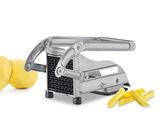 Pommes-Frites-Schneider aus Edelstahl in seitlicher Perspektive mit geschnittenen Kartoffelstäbchen und ganzen Kartoffeln im Hintergrund.