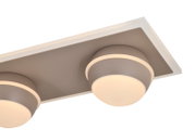 Nahaufnahme einer modernen LED-Deckenleuchte mit zwei runden Leuchtelementen auf einer rechteckigen Basis, seitliche Perspektive.