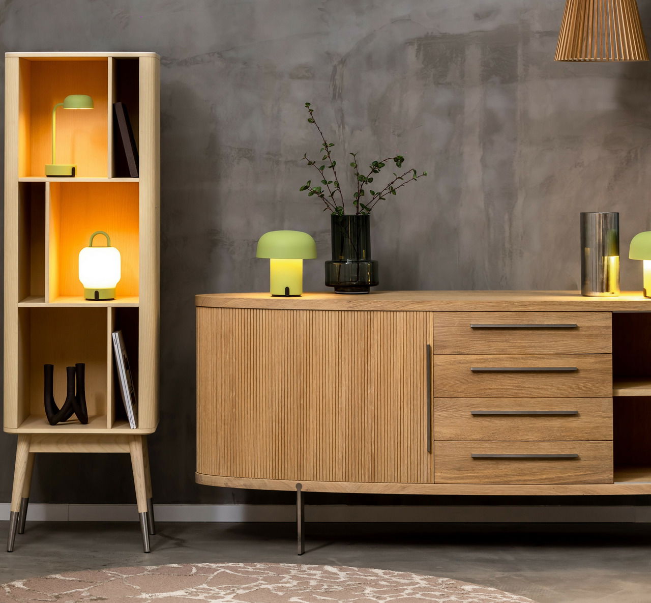 Moderne Wohnzimmermöbel mit einem hölzernen Sideboard und einem Regal, dekoriert mit stilvollen Tischlampen und Vasen, seitliche Perspektive.
