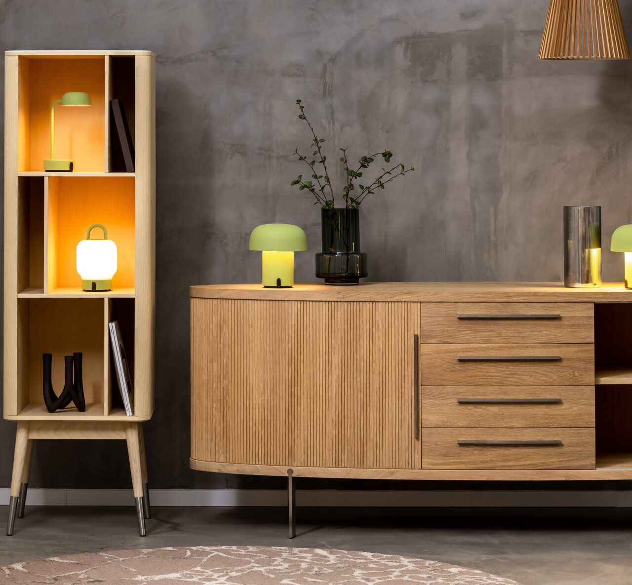 Moderne Wohnzimmermöbel mit einem hölzernen Sideboard und einem Regal, dekoriert mit stilvollen Tischlampen und Vasen, seitliche Perspektive.