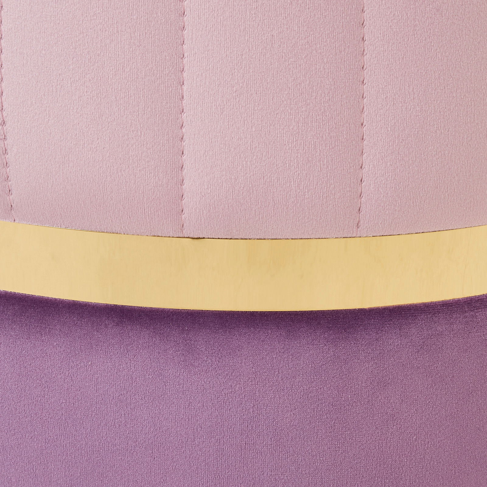 Nahaufnahme eines Hockers mit rosa und lila Polsterung sowie einem goldenen Akzentstreifen.